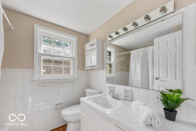 bathroom featuring tile walls, vanity, toilet, and a shower with curtain