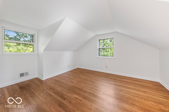 bonus room with light hardwood / wood-style floors, lofted ceiling, and plenty of natural light