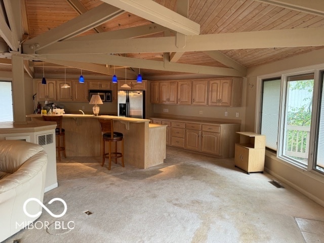 kitchen featuring lofted ceiling with beams, a breakfast bar, stainless steel appliances, decorative light fixtures, and light carpet