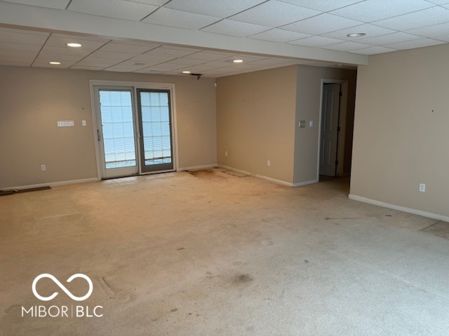 empty room with a paneled ceiling and light colored carpet