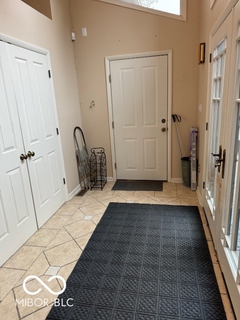 foyer entrance with lofted ceiling and light tile patterned floors