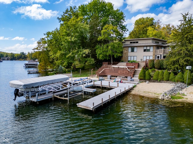 dock area featuring boat lift, a deck with water view, and stairs