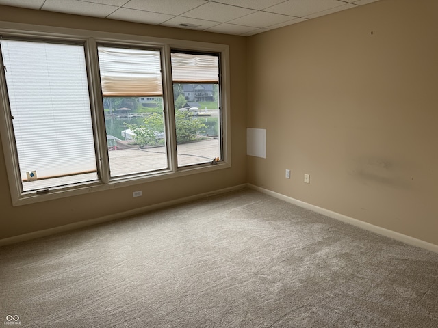 empty room with carpet floors, baseboards, and a drop ceiling