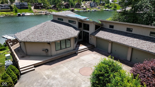 4161 S Summit Ln, Columbus, IN 47201 - view of front of home with a shingled roof, a residential view, a garage, driveway, and a deck with water view