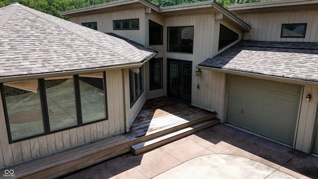 4161 S Summit Ln, Columbus, IN 47201 - view of exterior entry with roof with shingles, a garage, and driveway