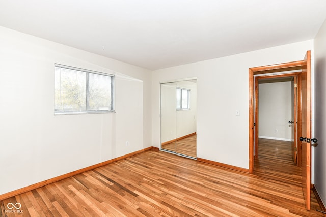 unfurnished bedroom featuring light hardwood / wood-style flooring and a closet