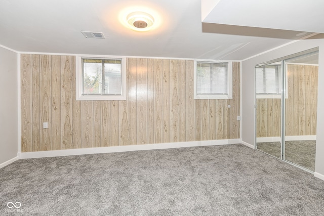 empty room featuring carpet and wooden walls