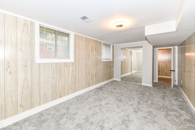 unfurnished bedroom with wood walls, a closet, and carpet floors