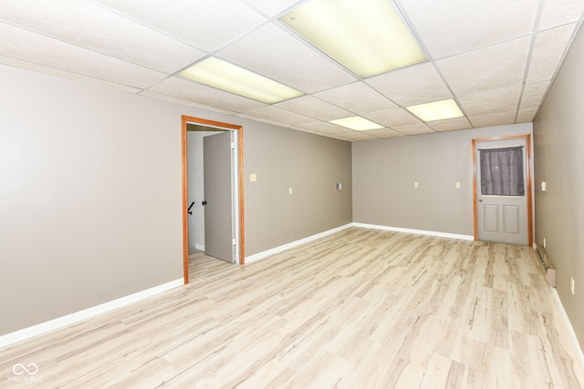 unfurnished room featuring light wood-type flooring and a paneled ceiling