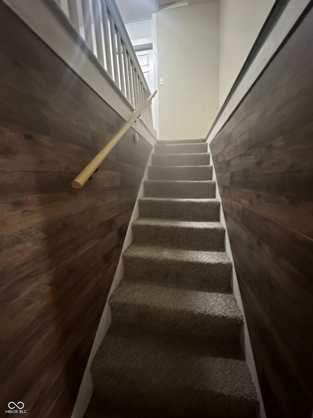 stairs featuring wooden walls