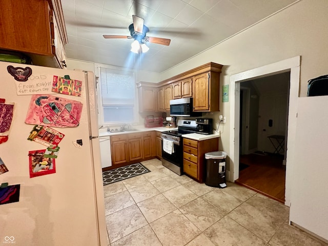 kitchen featuring sink, appliances with stainless steel finishes, light tile patterned floors, crown molding, and ceiling fan