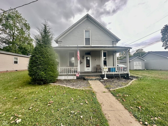 view of front of property featuring a front yard, a porch, and a shed