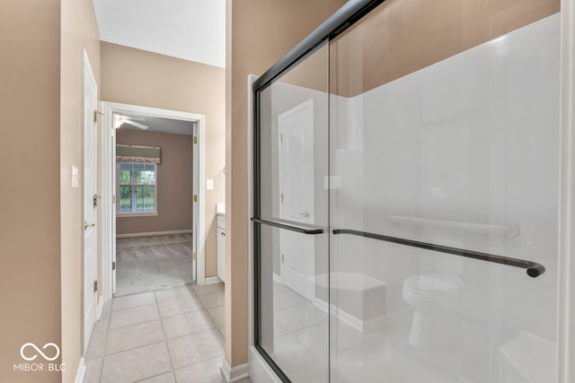 bathroom featuring vanity, toilet, an enclosed shower, and tile patterned flooring