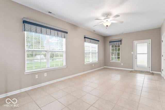 spare room with ceiling fan and light tile patterned floors