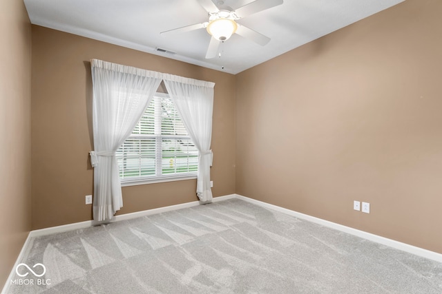 carpeted spare room featuring ceiling fan