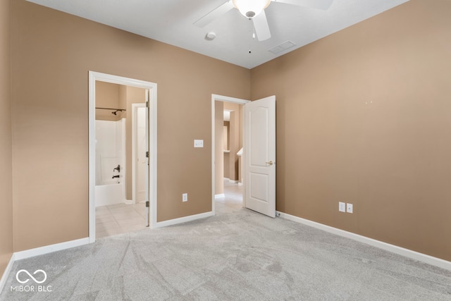 unfurnished bedroom featuring ceiling fan, ensuite bath, and light carpet