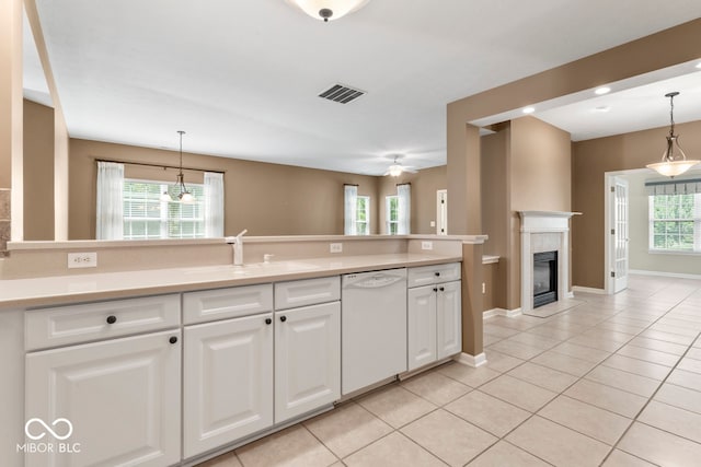 kitchen featuring a wealth of natural light, dishwasher, sink, and white cabinets