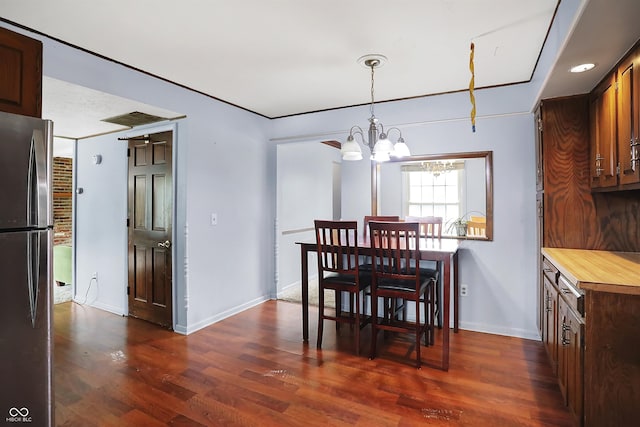 dining space with dark hardwood / wood-style floors and a chandelier