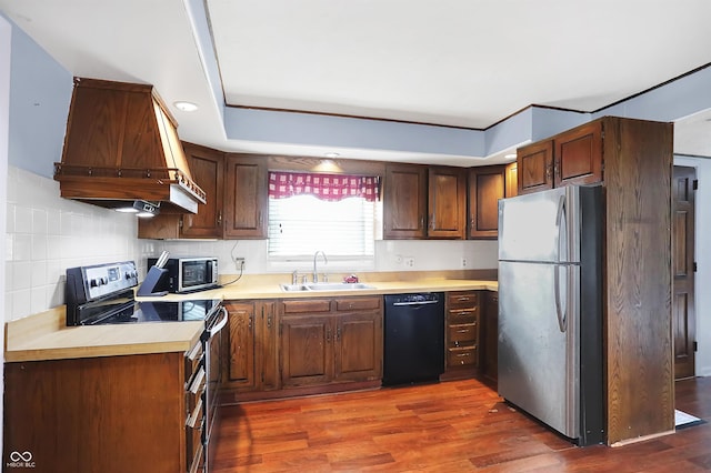 kitchen with premium range hood, sink, tasteful backsplash, dark wood-type flooring, and appliances with stainless steel finishes