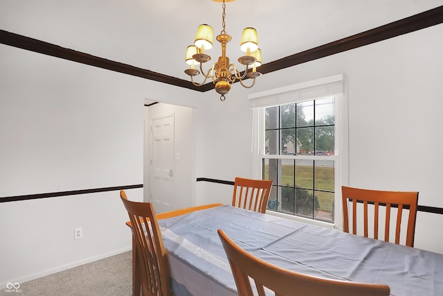 carpeted dining room featuring an inviting chandelier and ornamental molding