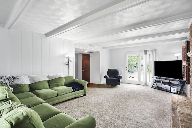 carpeted living room with beam ceiling