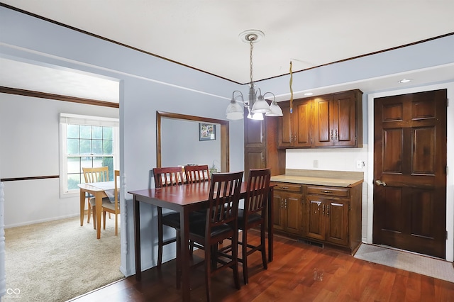 dining room with dark hardwood / wood-style flooring and a notable chandelier