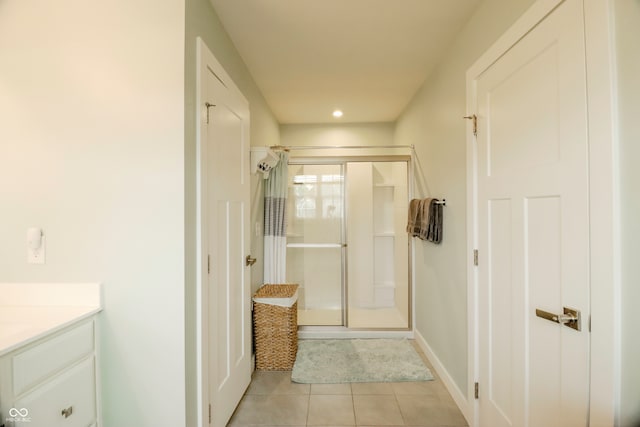 bathroom featuring walk in shower, vanity, and tile patterned floors