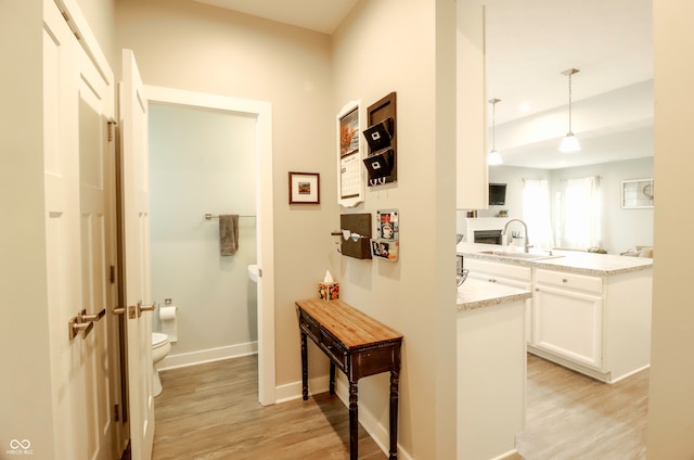 hall featuring light wood-type flooring and sink