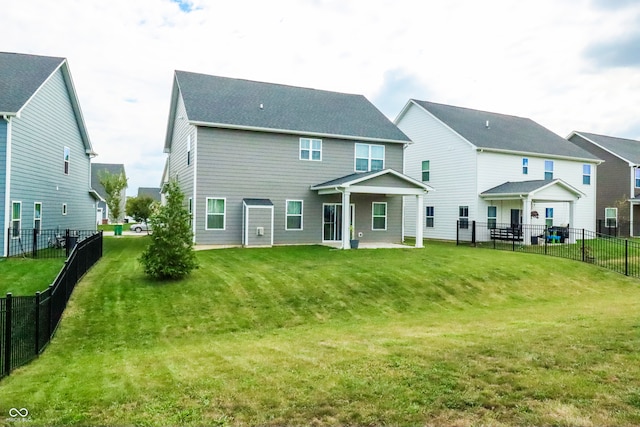 rear view of house with a patio and a yard