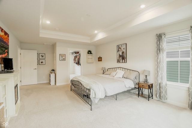 bedroom with a tray ceiling and light colored carpet