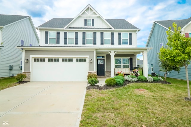 view of front facade with a porch, a garage, and a front lawn