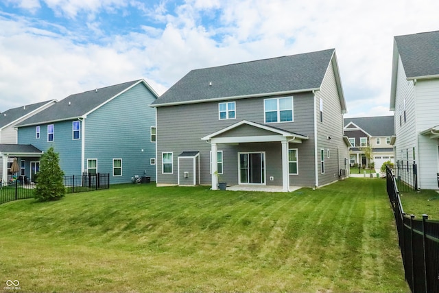 back of house featuring a lawn and a patio