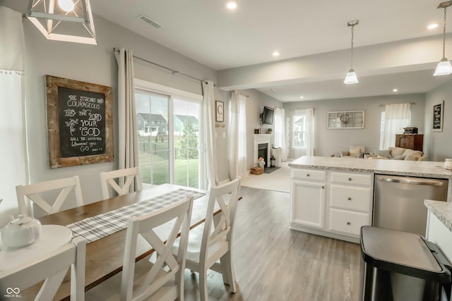 kitchen featuring a healthy amount of sunlight, white cabinetry, pendant lighting, and dishwasher