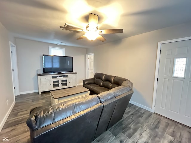 living room with ceiling fan and dark wood-type flooring