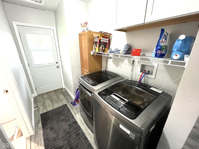 laundry room featuring cabinets, dark wood-type flooring, and washing machine and dryer