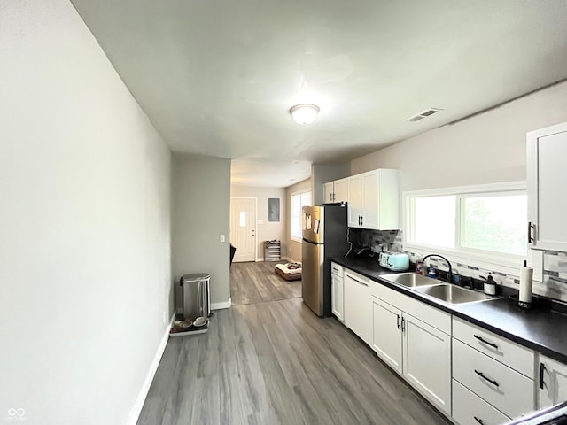 kitchen featuring stainless steel fridge, white cabinetry, and sink