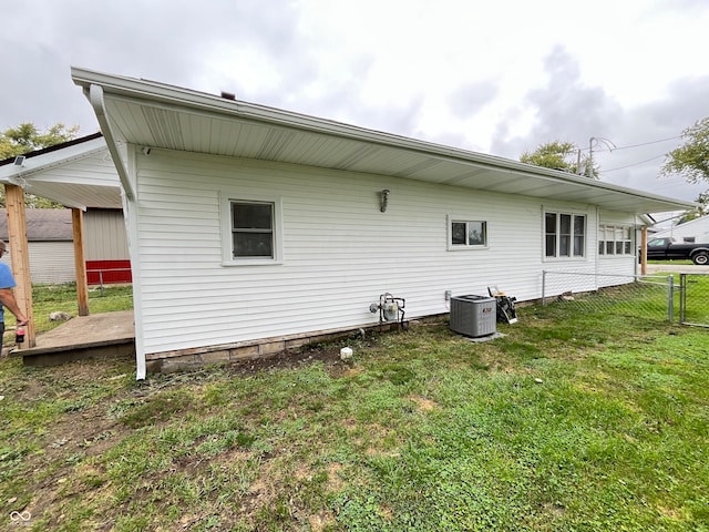 back of property featuring central AC and a yard