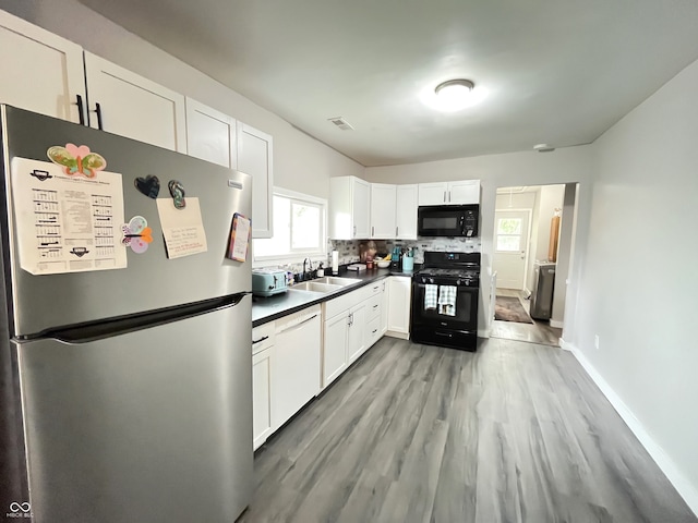 kitchen with white cabinetry, backsplash, light wood-type flooring, black appliances, and sink