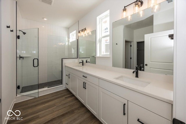 bathroom featuring a shower with door, vanity, and hardwood / wood-style flooring