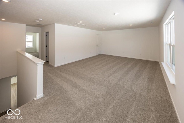 carpeted empty room with a textured ceiling