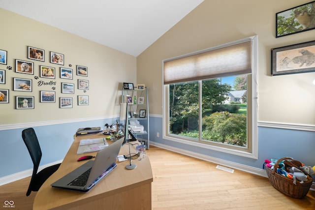 office with light wood-type flooring and vaulted ceiling