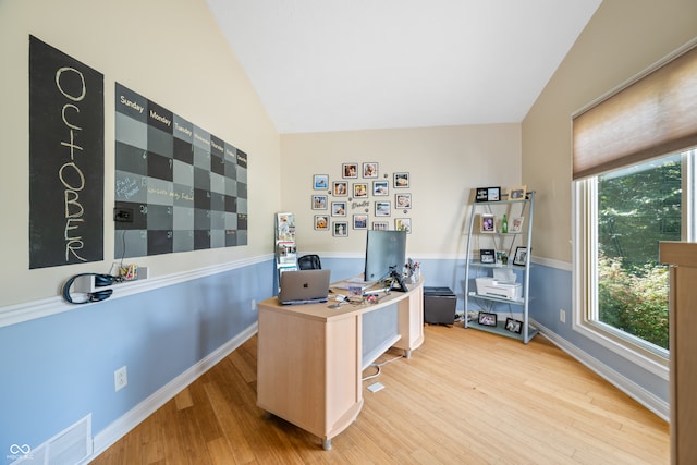 office space featuring vaulted ceiling and light hardwood / wood-style flooring