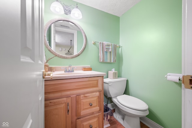 bathroom featuring vanity, toilet, and a textured ceiling