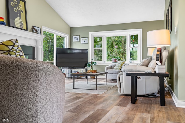 living room with a textured ceiling, lofted ceiling, and hardwood / wood-style floors