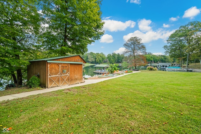 view of yard featuring a storage shed and a water view