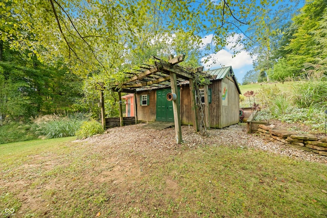 view of yard featuring a pergola and an outbuilding