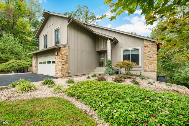 view of front of property with a garage and central AC