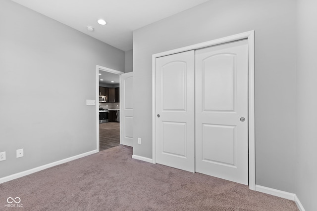 unfurnished bedroom with carpet flooring and a closet