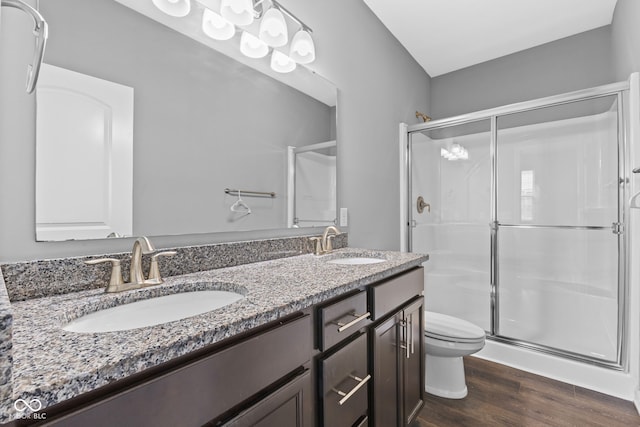 bathroom featuring hardwood / wood-style floors, vanity, toilet, and a shower with shower door