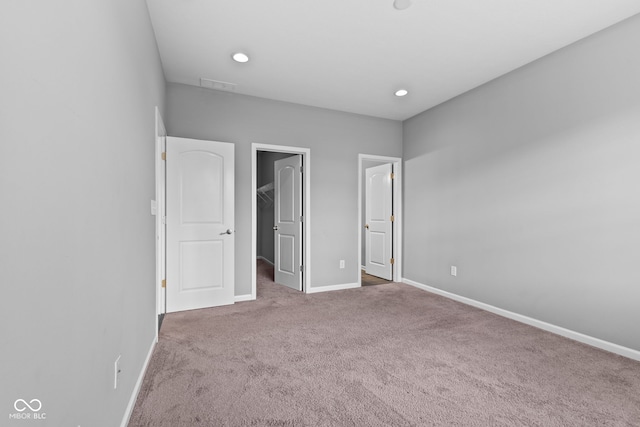 unfurnished bedroom featuring carpet flooring and a spacious closet